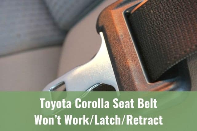 Car seat belt latch resting on seat cushion