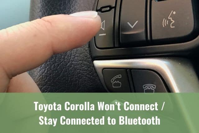 A finger pressing on bluetooth speaker button inside a car
