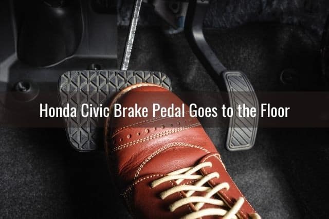 A foot pressing down on a car brake pedal