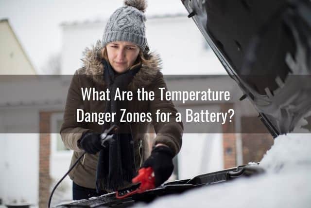 Woman jump starting car battery in winter