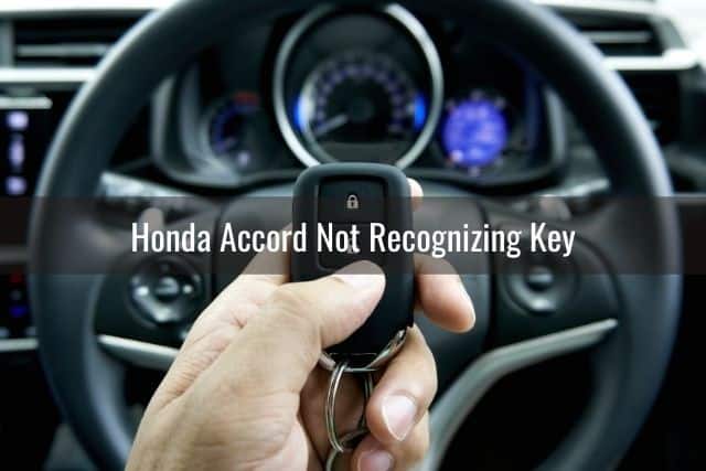 Handing holding car key fob in front of steering wheel