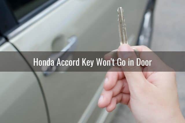 Hand holding car key beside car door