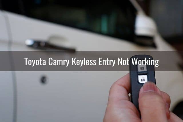 Hand pressing car keyless remote in front of white car