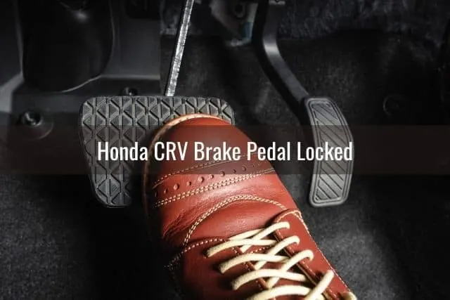 Leather shoe pressed down on car brake pedal