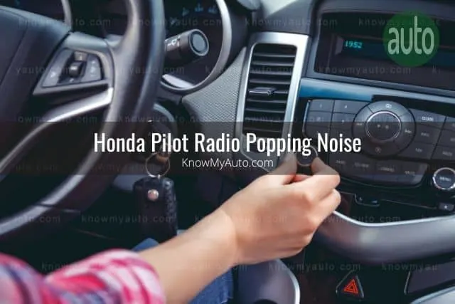 Fingers adjust car radio volume knob