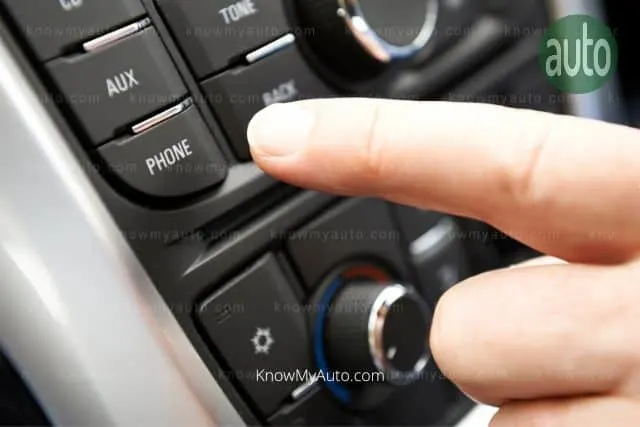 Finger about to press the phone button in a car